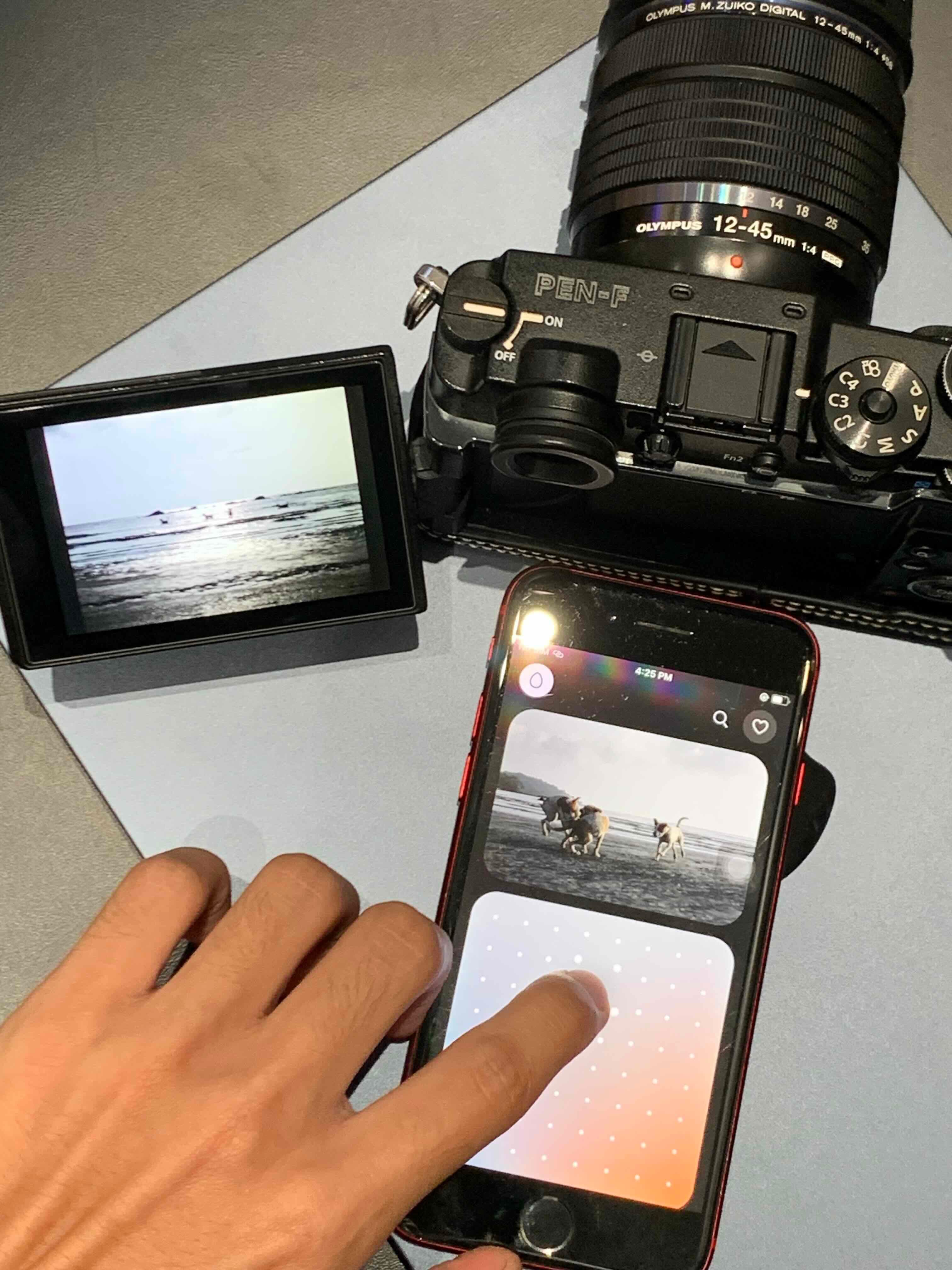 OM Film Lab running on a phone next to an Olympus camera